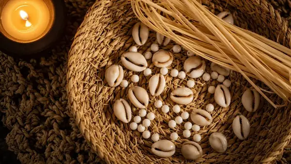 Cowrie shells on a straw sieve